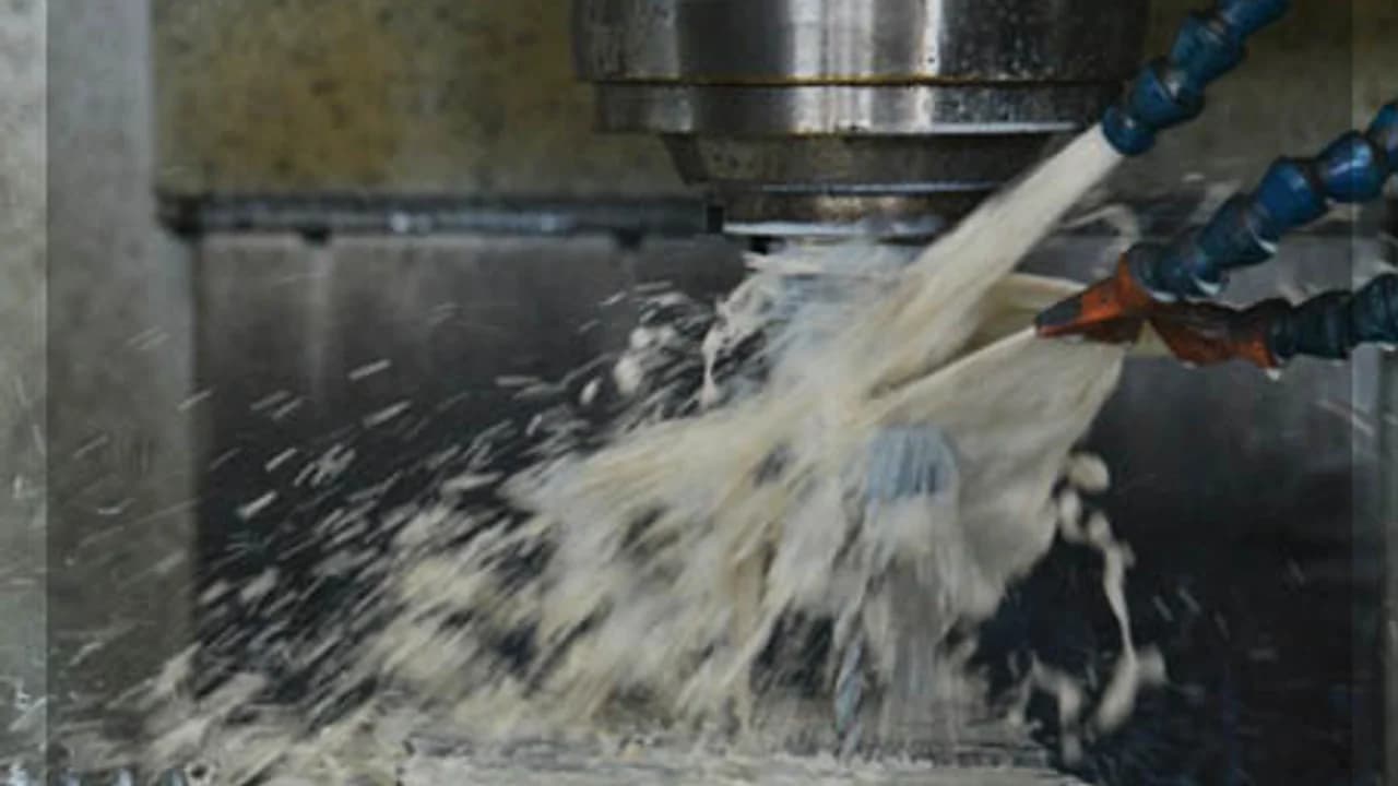 آلة CNC على خط إنتاج فرشباف تُشغّل قطعة مع رذاذ التبريد